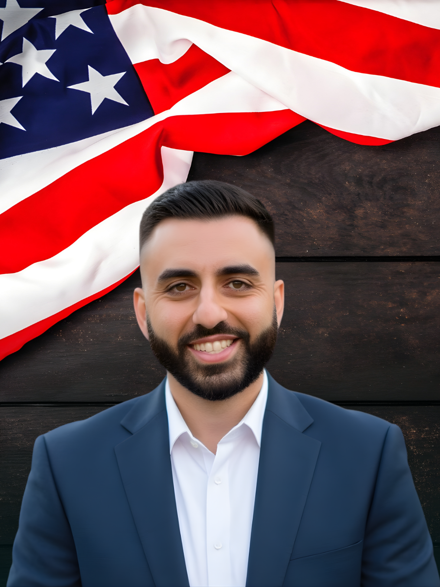 Congressional Candidate smiling in front of an American Flag and Sturdy Wood Plans 